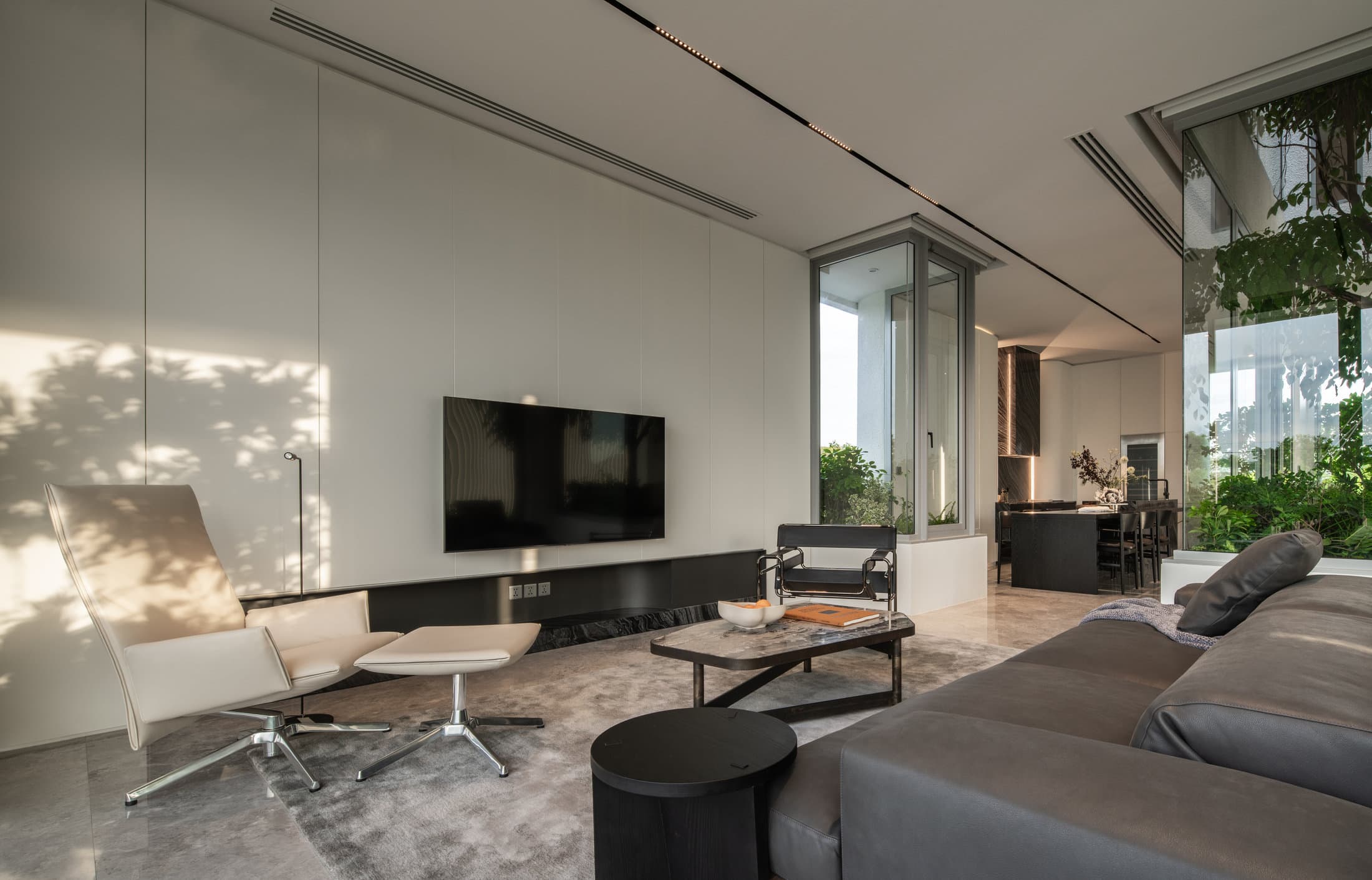 Completed ARQ10 L-House family living room opening to a planted courtyard